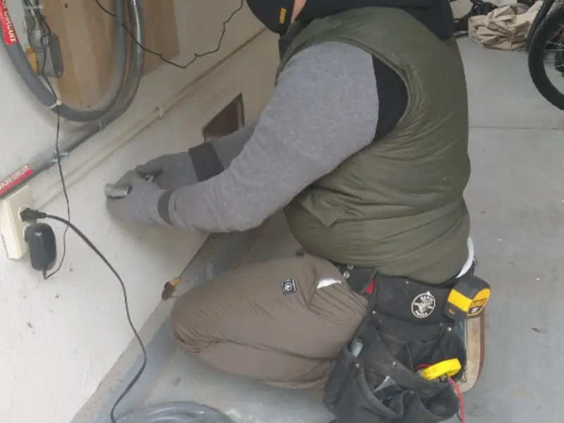 Electrician performing outlet wiring in a Mesa garage